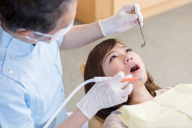 歯医者で治療をする女性
